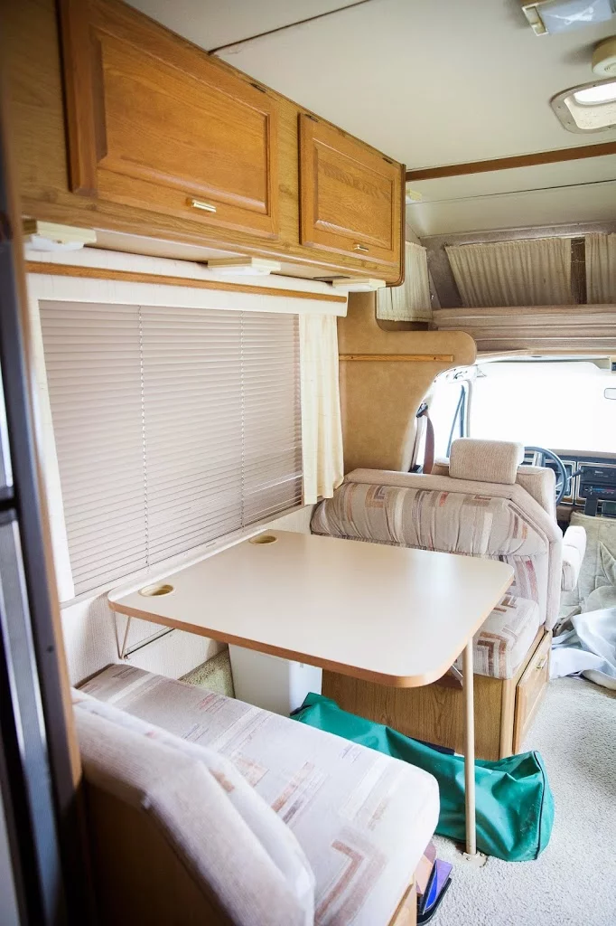 Rv kitchen with table and booths and cabinet doors