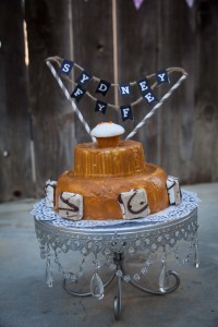 Cake on top of a silver cake stand with a banner that says Sydney Fyfe