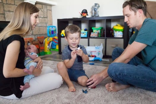 newborn lifestyle session family of 4 sitting on floor of play room