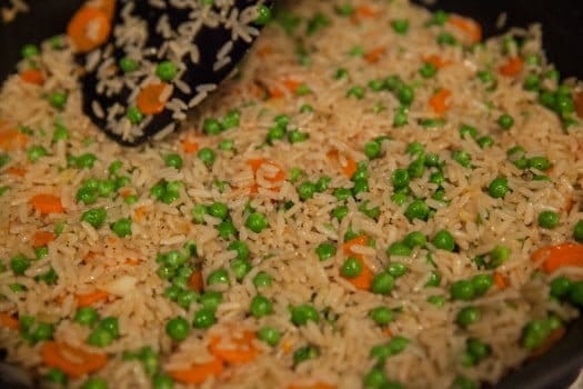 rice carrots and peas in pan  