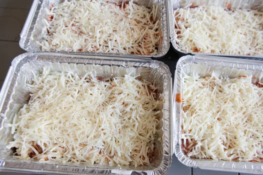 Container tin with red sauce noodles cheese in multiple layers