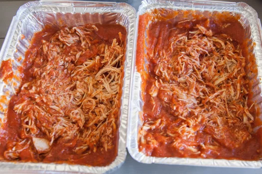 Shredded chicken and red pasta sauce in two separate containers