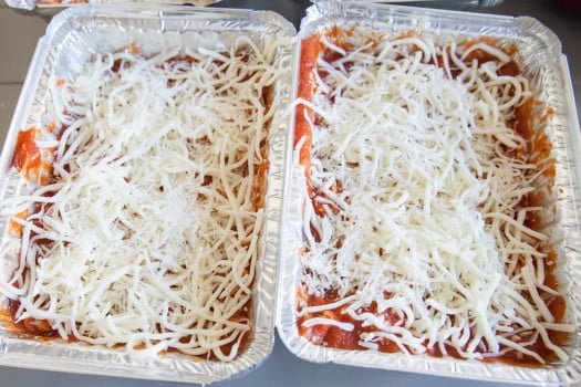 Shredded chicken, red sauce, and mozzarella cheese in two separate containers 