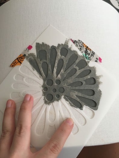 Grey colored Stencil being applied to flower pattern on lampshade