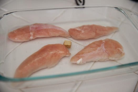 Four pieces of chicken in glass dish