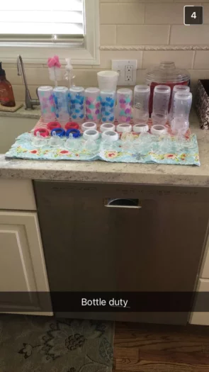 Baby bottles washed and cleaned and spread out on towel on kitchen counter