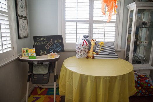 present table that has chalk board sign that says "dump presents here" with dump truck drawn on it 