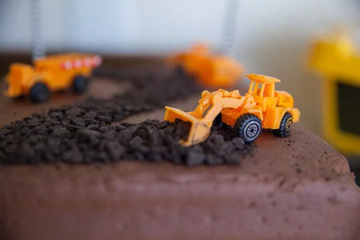toy tractor scooping up oreo crumbs on cake