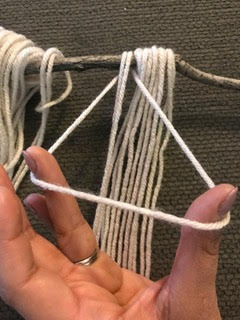 tying yarn onto stick 
