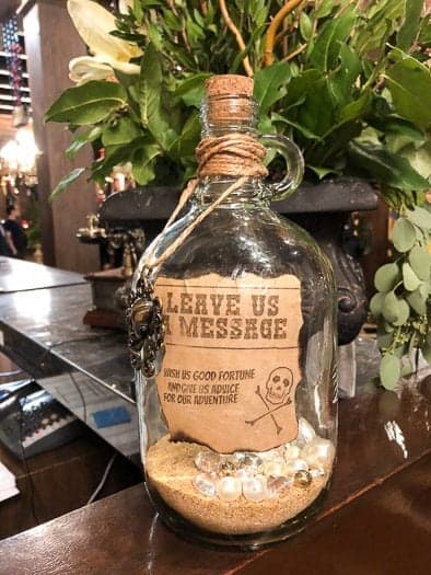 Pirate styled bottle with sand in it and leave us a message sign