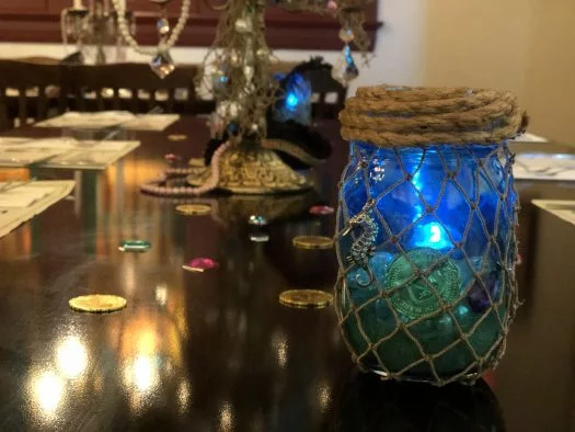 Netted ocean themed mason jar with dining table background and gold coins