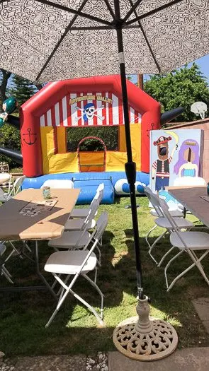 Pirate bounce house in the background with tables and chairs in the foreground