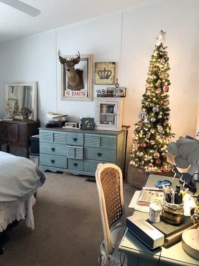photo of bedroom with desk deer head and Christmas tree