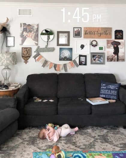 Finished gallery wall over the couch and a baby laying on the floor 