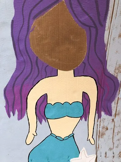 Painted in chalk drawing of mermaid with purple hair and blue bikini