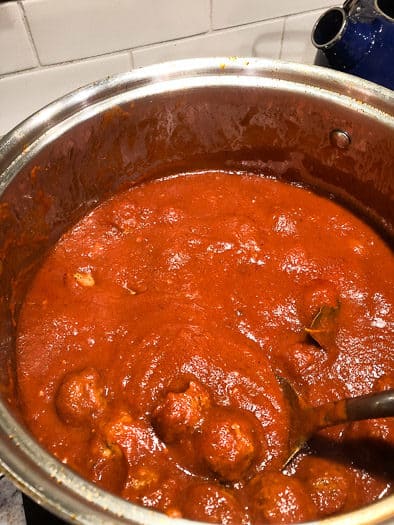 meatballs in a large pot with meat sauce