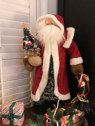 Santa holding a small Christmas tree
