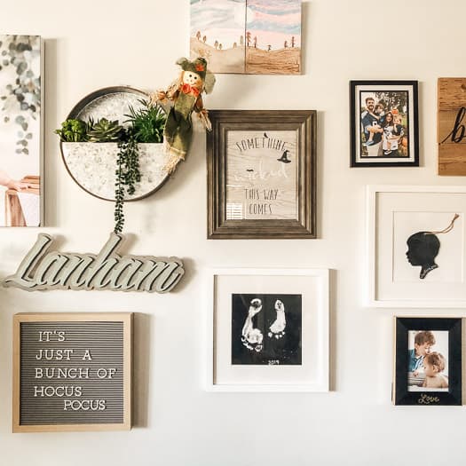 Gallery wall with a mixture of printables, artwork, pictures and greenery.