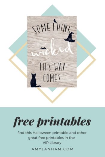 free printables, shows the printable has a wood background and says something wicked this way comes with a black cat in the lower left corner and a black hat over the d, a bat for the dot over the i, and a crow perched on the T.