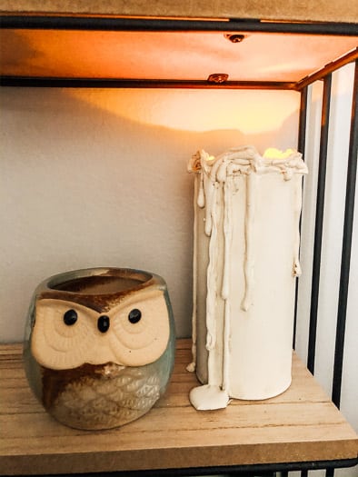 Finished realistic flameless candle next to owl faced mug