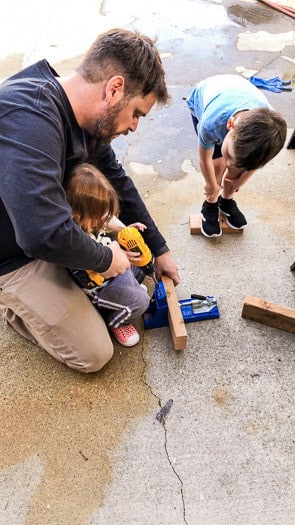 padre e figli che lavorano su un pezzo di legno insieme 