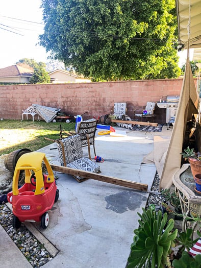 backyard with kid toys down pieces of wood and patio furniture 