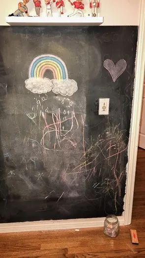 Magnetic chalkboard with rainbow and drawings on it 