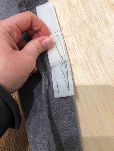 Showing Velcro being sewn onto grey fabric.