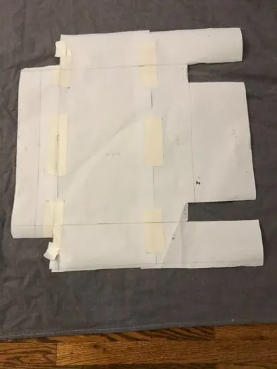 Paper template of the chair cover laying over grey fabric