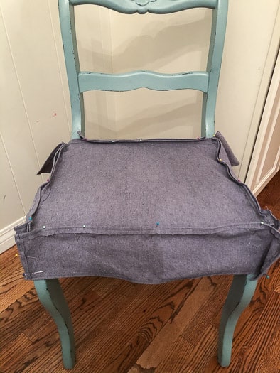 The grey fabric pinned inside out to the blue chair