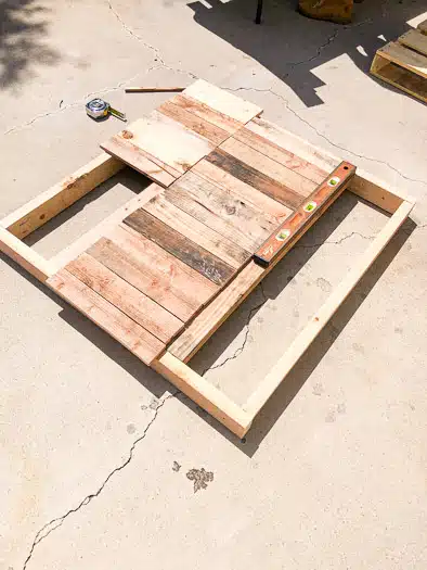 Pallet pieces laid out on top of the 2x4 base