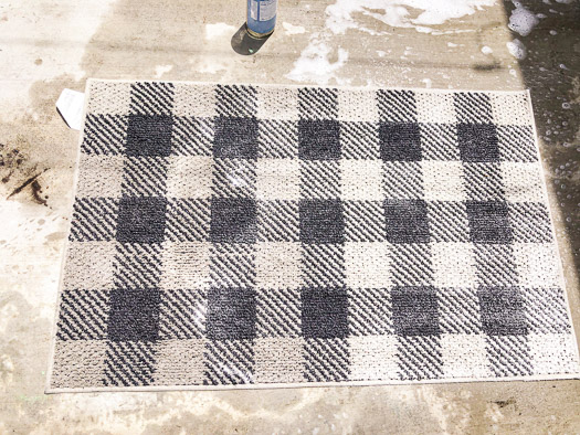 black and white checkerboard rug with right side clean and the left side the white looks dirty.