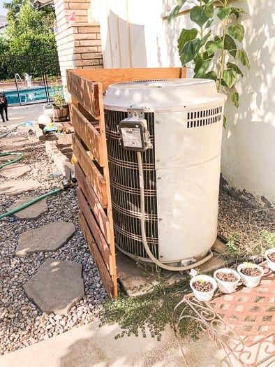 back of an air conditioning unit with a redwood slat cover around it