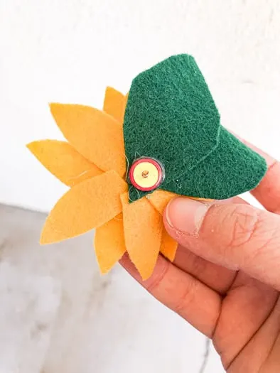 showing the back a felt sunflower with a push pin glued to the back
