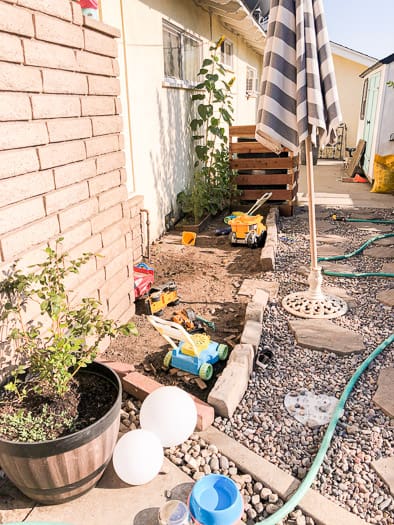 Dirt strip with kids toys and rock surrounding