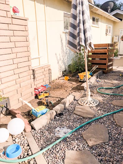 dirt area with a stone barrier separating it from rock area