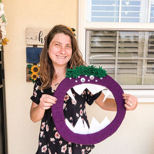 Woman holding a purple monster wreath