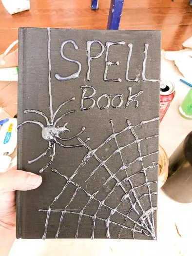 Cover of the book with Spell Book and a spider and web in hot glue