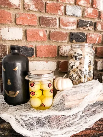 pumpkin jar next to skulls in jar and eyeball ping pong balls