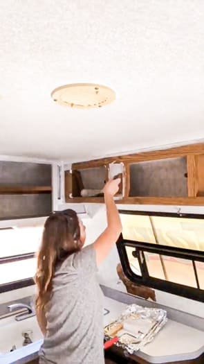 Me painting the upper cabinets with primer.