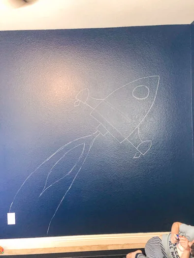 Chalk outline of the rocket ship on a blue background.