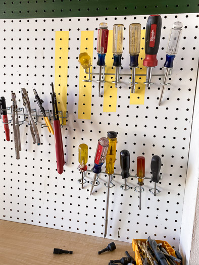 Screwdrivers hung on a pegboard with the multiple tool holder from National Hardware