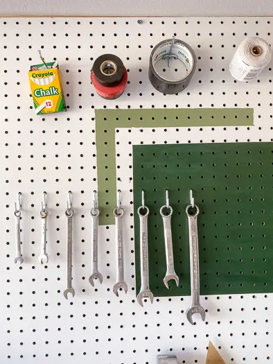 wrenches and tape hang on a pegboard using curved hooks and single hooks from National Hardware