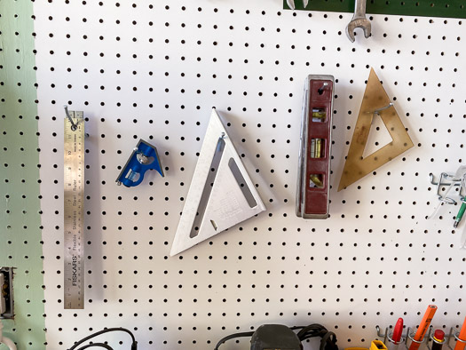 squares, rulers, and levels hung on a pegboard using single hooks from National Hardware