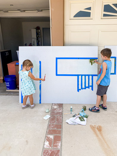 Kids painting a pegboard