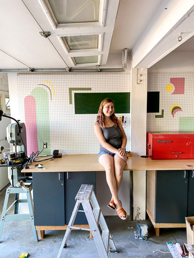 woman sitting in front of a pegboard with various shapes in green and pink