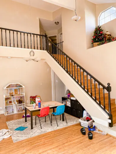 Table in the bottom left with stair railing above. Stair railings are painted black.