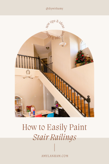 How to Easily Paint Stair Railings pin image with a picture of black stair railings and wood stairs.