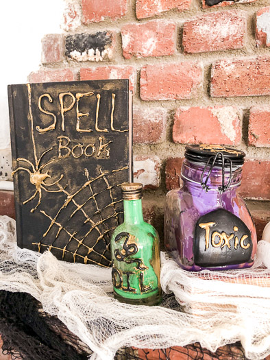 Spell book on the left and two poison bottles on the right. One says oil with a drawing of a snake and the other says toxic.