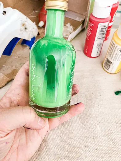Green and white paint dripping down the inside of a closed jar.